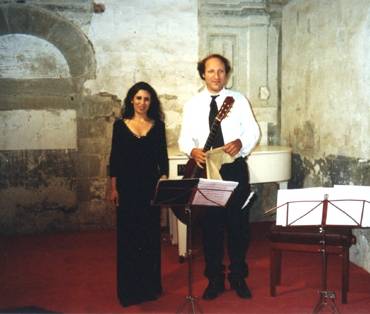 Beatriz Lozano (a sinistra) e Massimo Agostinelli (a destra con la chitarra in mano) in piedi dopo un concerto.