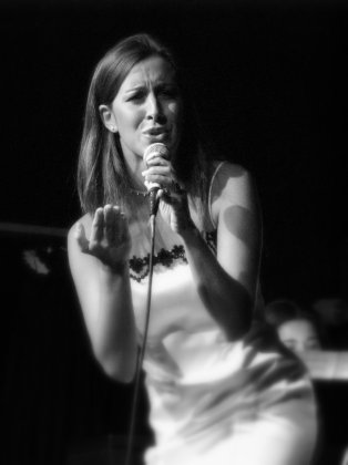 Ana Karina Rossi con il microfono nella mana sinistra, sta cantando.